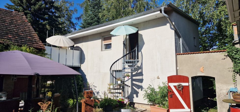 Außenansicht der Ferienwohnung Geltow mit Terrasse und Wendeltreppe.